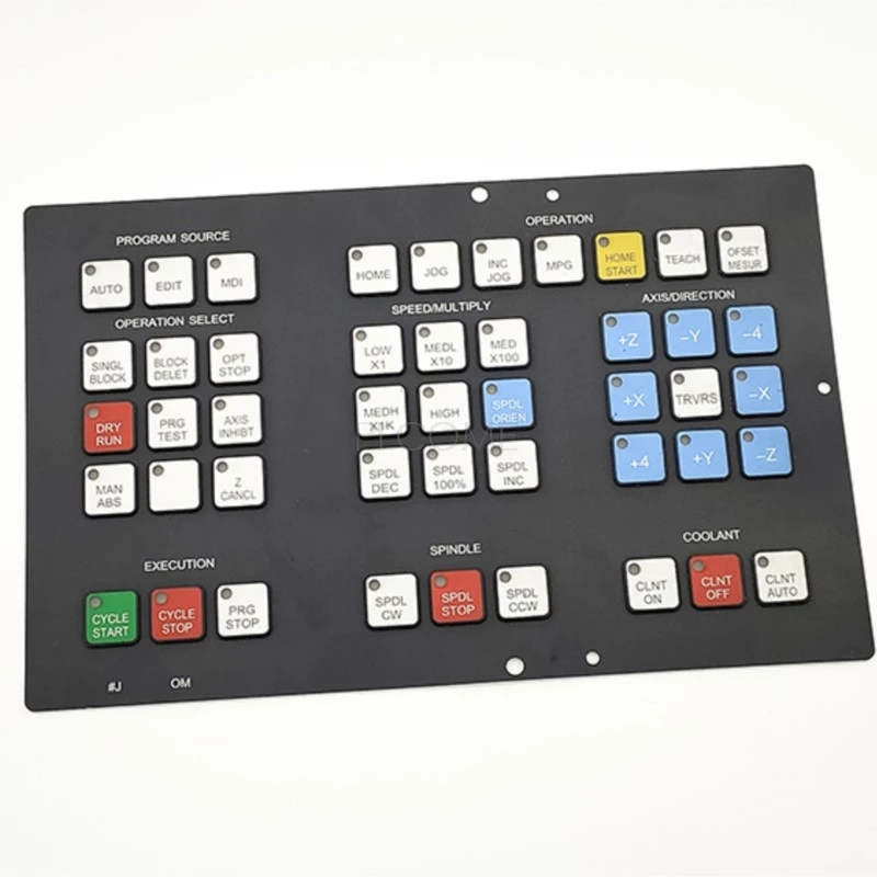 Black 46-key silicone membrane operator panel keypad for Fanuc Series 0M machining centre control, with colour-coded cycle start, spindle and axis direction keys, printed code #J OM along the bottom edge.